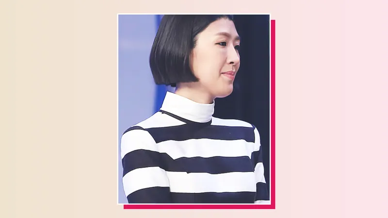 Hong Jin-kyung with a sleek black bob and a black-and-white striped high-neck top, smiling in profile at an awards show
