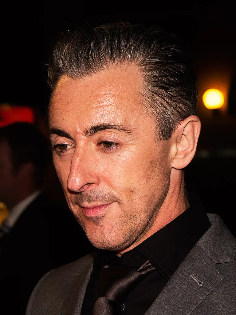 Alan Cumming in a dark suit at a film festival event at night