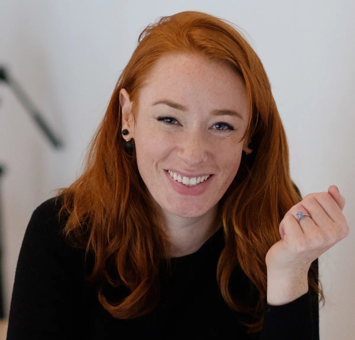 Hannah Fry smiling, with long red hair, at a conference