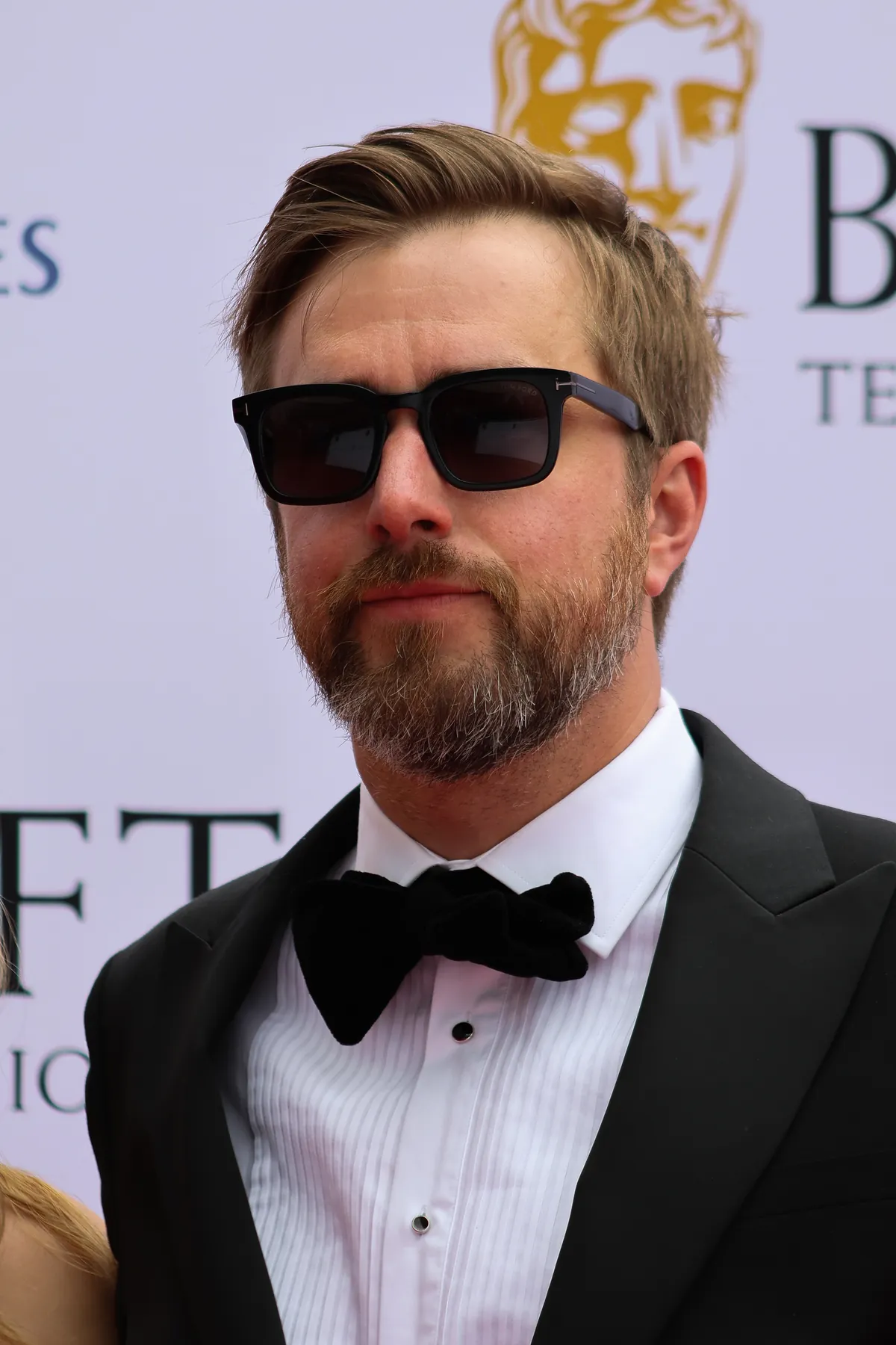 Iain Stirling in a tuxedo and sunglasses on the BAFTA red carpet